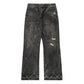 Distressed black denim jeans with a relaxed, bootcut fit. The jeans feature a heavily worn aesthetic, including brown splatter-style detailing, ripped patches on the right leg, and frayed hems. A small embroidered logo is visible on the right pocket.